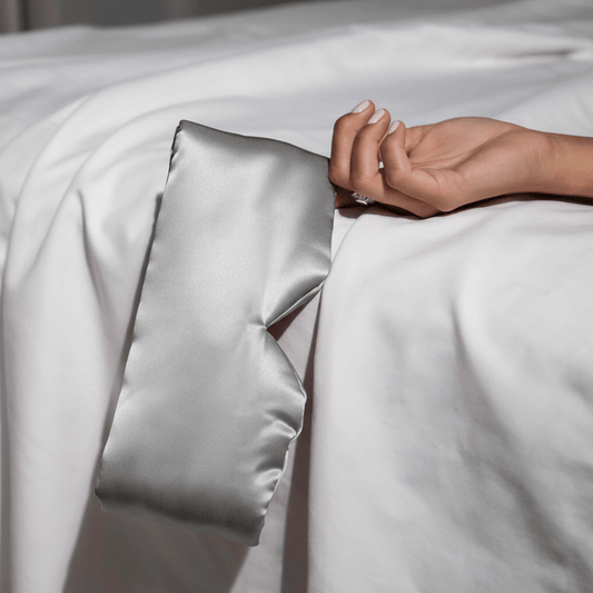 Masque de sommeil – 100 pour cent soie de mûrier posé sur draps blancs